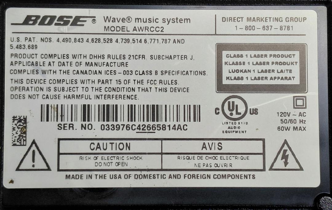 Bose Wave Music System bottom label showing MODEL AWRCC2 and serial number ending in AC