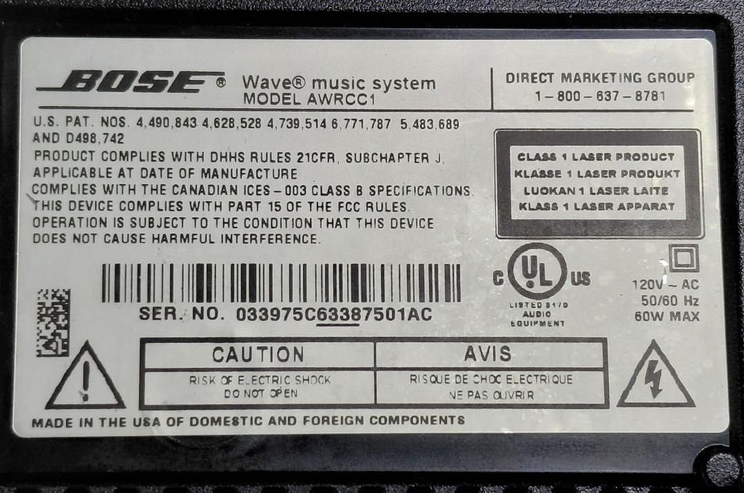 Bose Wave Music System bottom label showing MODEL AWRCC1 and serial number ending in AC